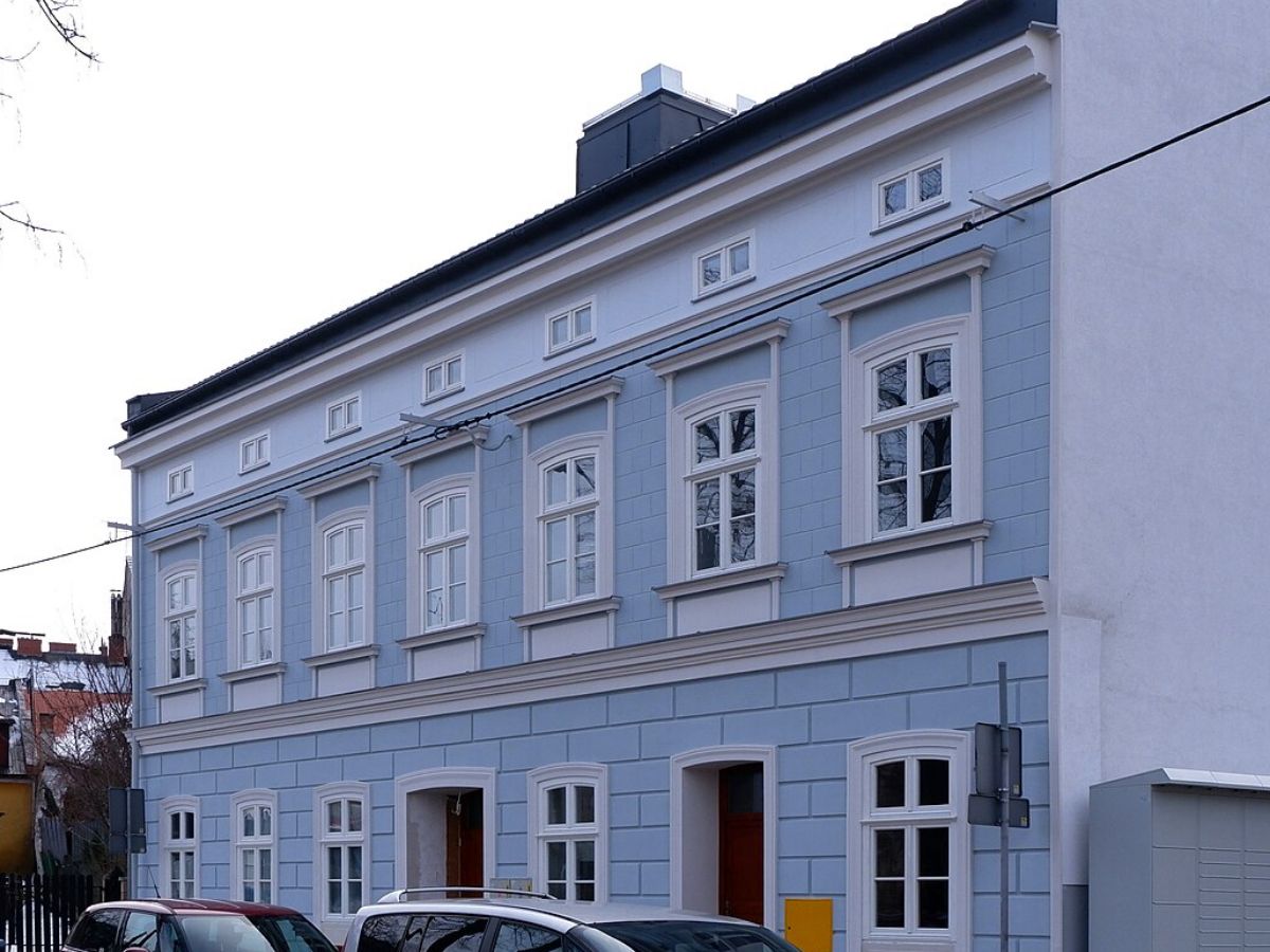 La même maison de ville après travaux, façade bleue, moulures reprises, menuiseries et couverture neuves.