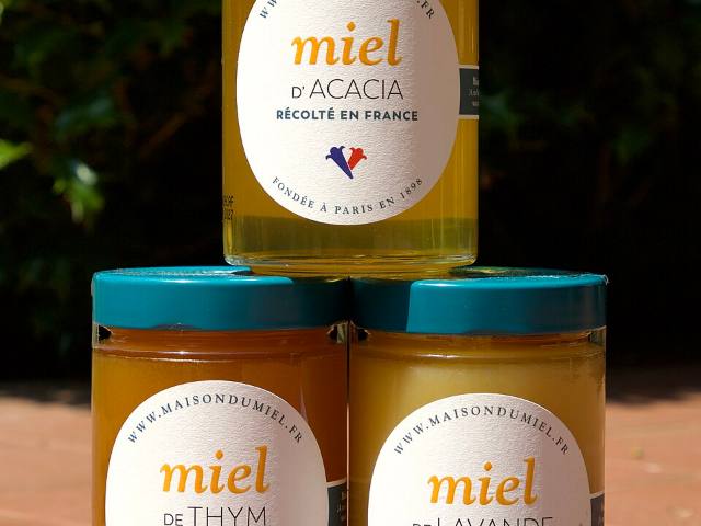 Pots de miel français empilés, étiquettes jaunes