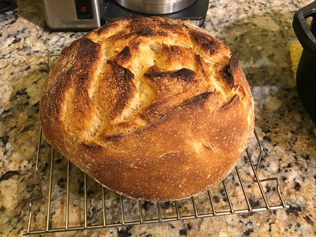 Pain au levain à croûte dorée, sorti du four, posé sur une grille