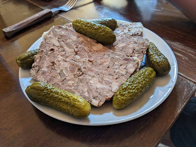 Tranche de terrine de campagne servie avec des cornichons