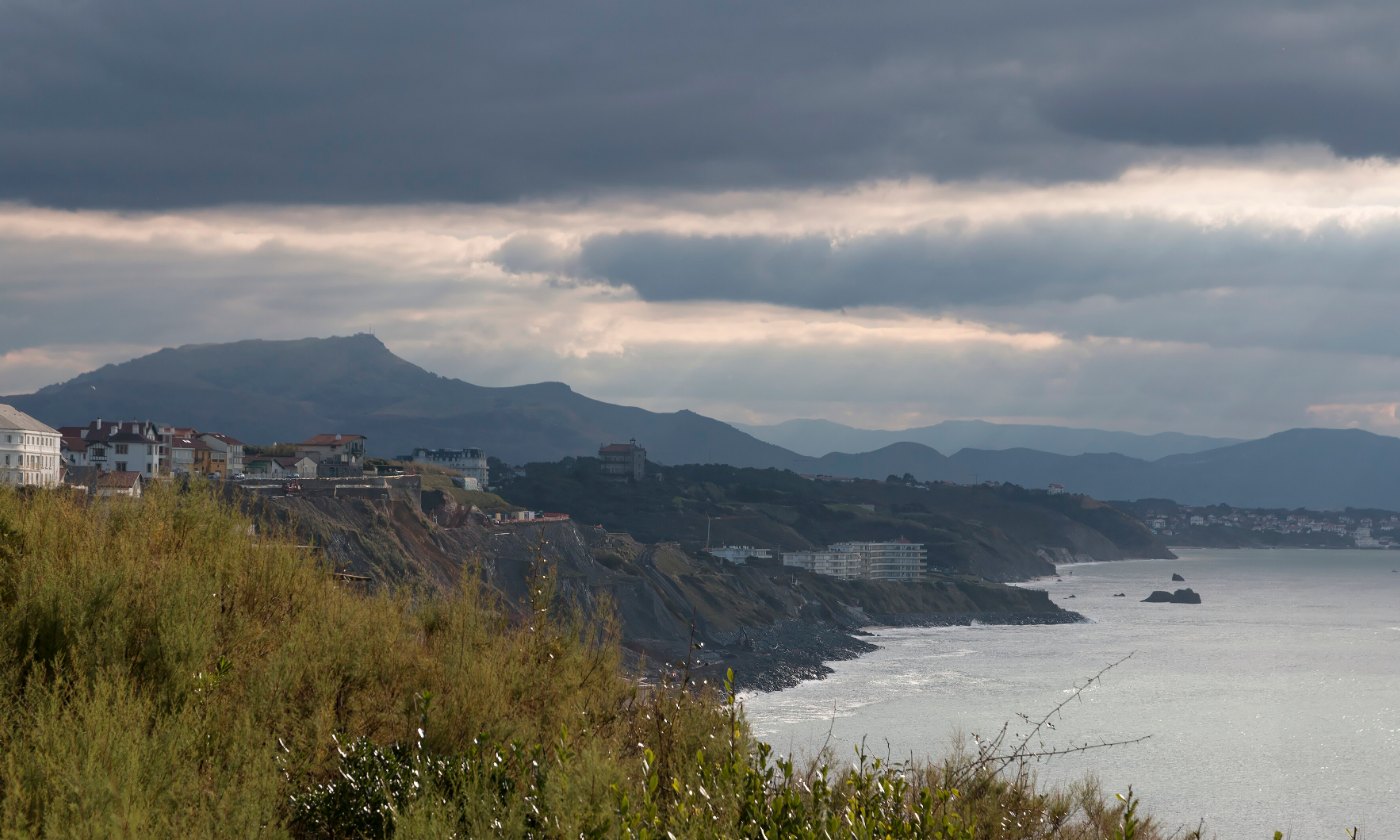 La côte basque vue depuis la falaise, maisons sur le plateau et montagnes au fond