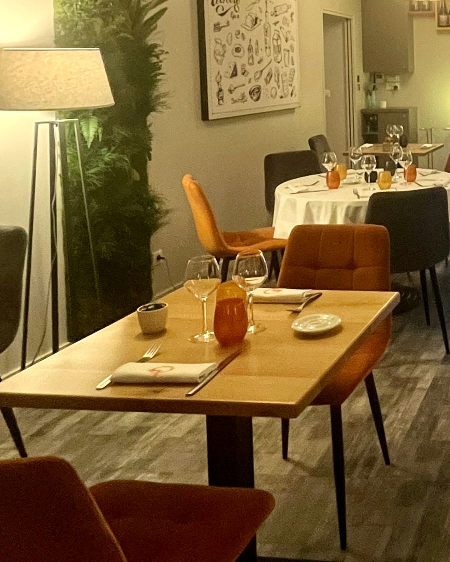 Table de deux dressée dans la salle, verres et serviettes en place