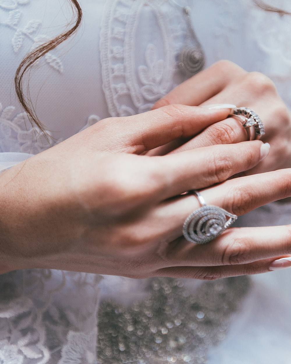 Deux mains posées l'une sur l'autre, ongles en manucure française claire
