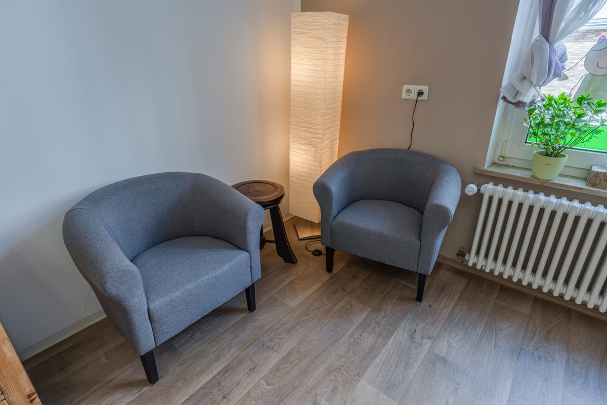 Coin d'entretien du cabinet, deux fauteuils et une lampe près de la fenêtre.