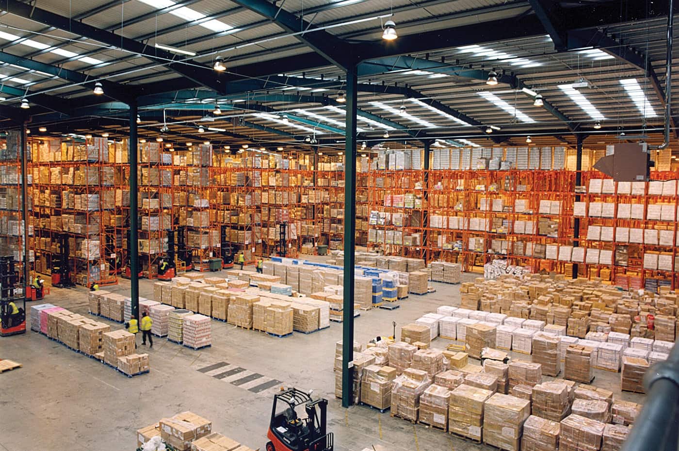 Intérieur de l'entrepôt, racks à palettes sur plusieurs niveaux et allées de préparation