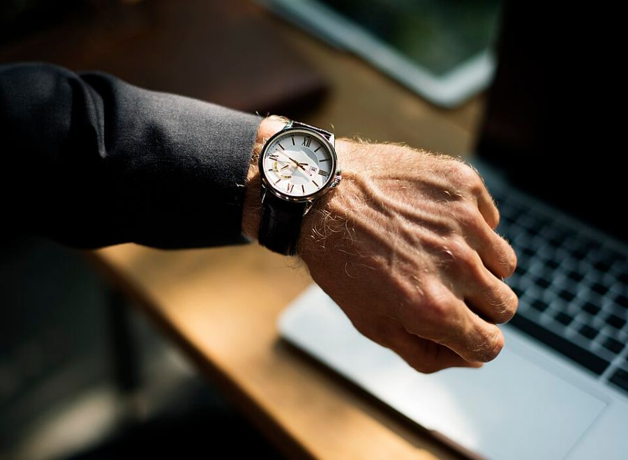 Montre à bracelet de cuir portée au poignet, cadran clair