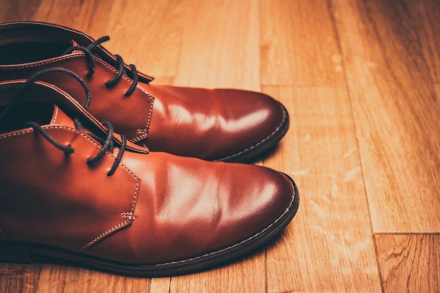 Paire de bottines en cuir marron posées sur un parquet
