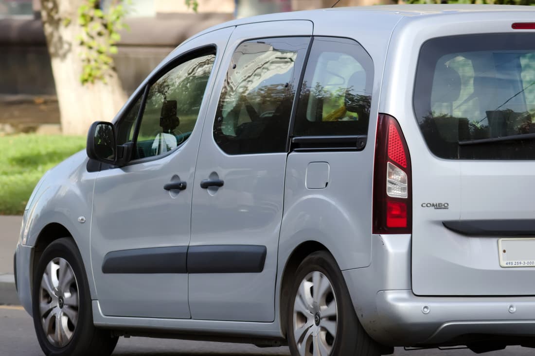 Utilitaire vitré gris à porte latérale coulissante, vu de trois quarts arrière