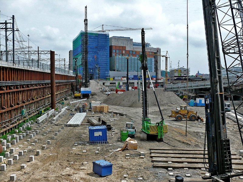 Vaste fouille de terrassement sur un chantier de bâtiment, atelier de battage de pieux et palplanches le long de la fouille.