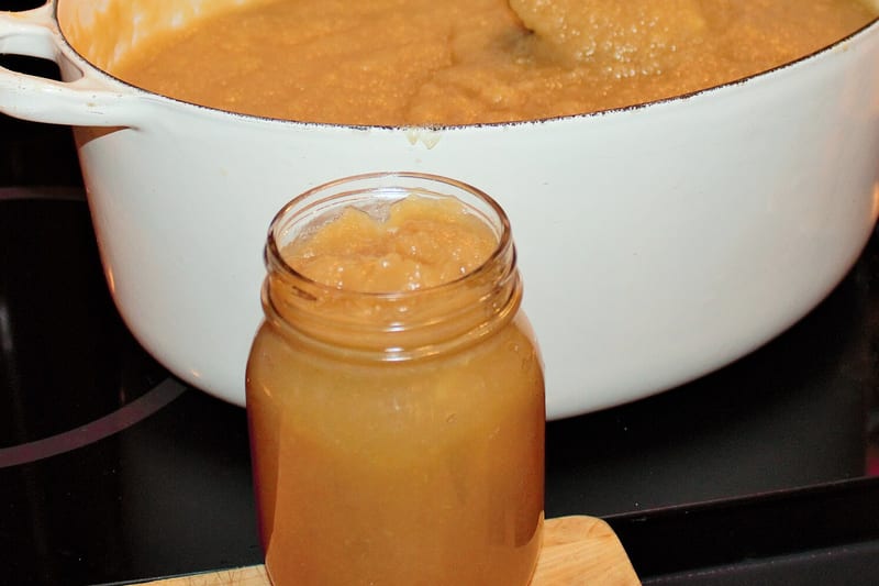 Bocal de compote de pommes devant la marmite de cuisson