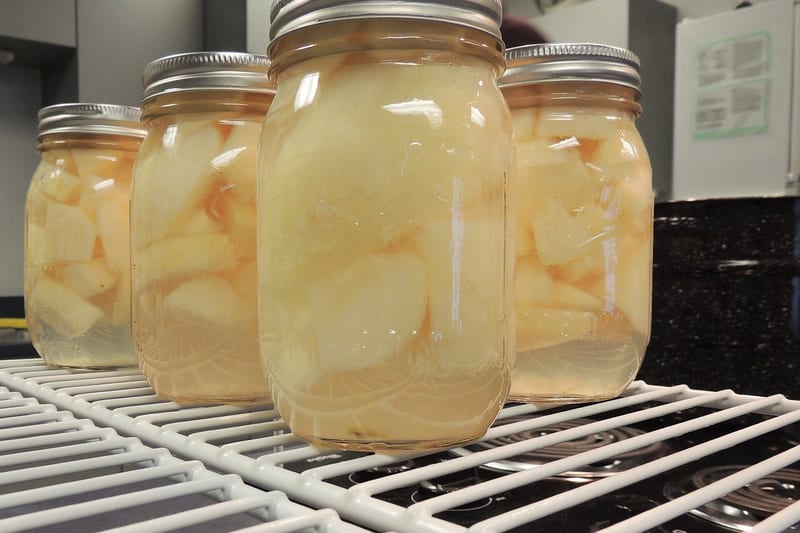 Bocaux de poires au sirop alignés après stérilisation