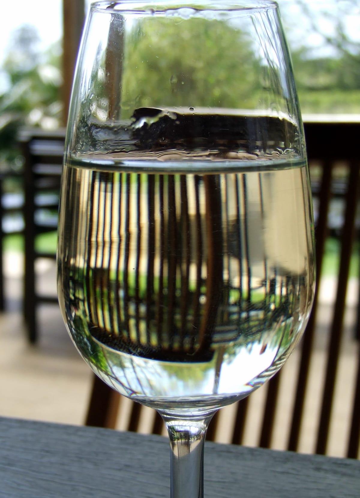 Verre de vin blanc posé sur une table, à l'ombre devant le caveau