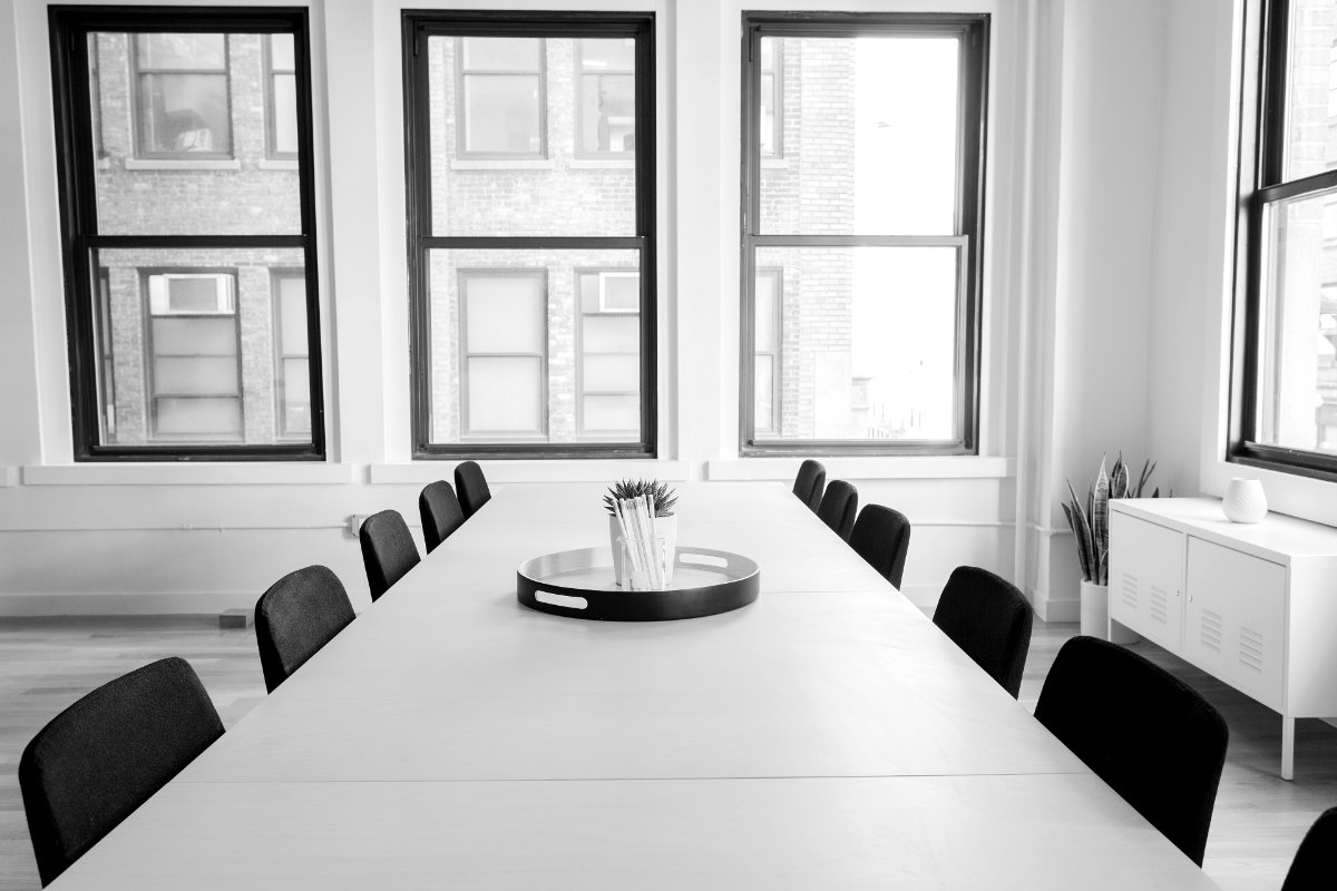 La salle de réunion du cabinet, table longue et fenêtres sur rue.