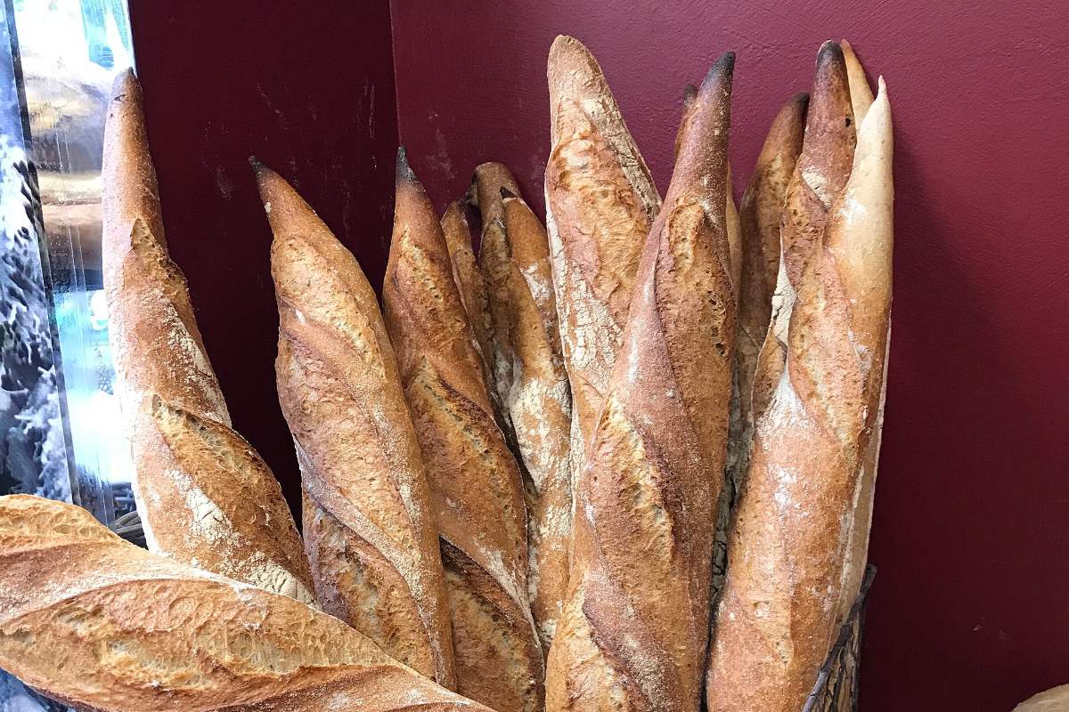 Baguettes de tradition debout dans un panier de boutique, étiquette de prix écrite à la main
