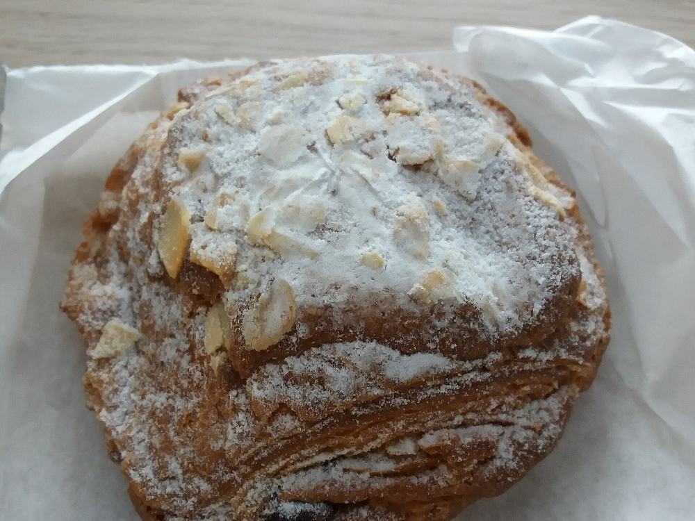 Viennoiserie feuilletée aux amandes effilées, saupoudrée de sucre glace