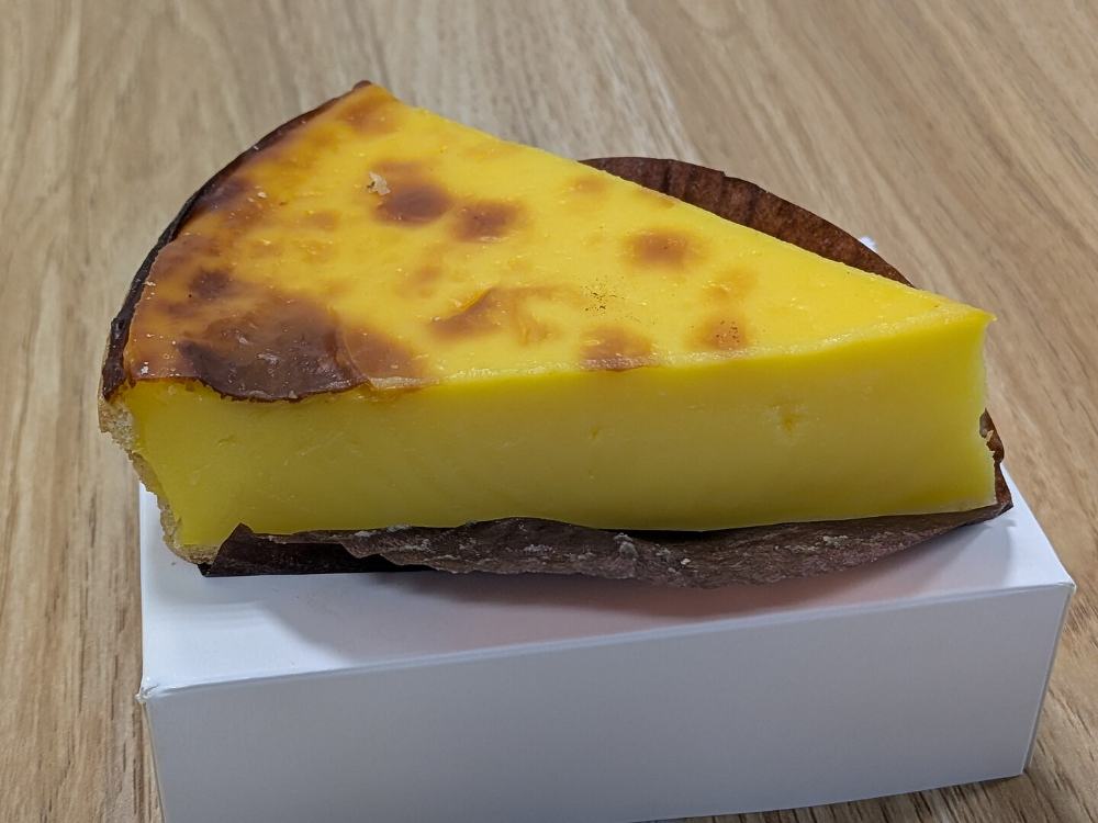 Part de flan pâtissier à la vanille, dessus caramélisé, sur son carton