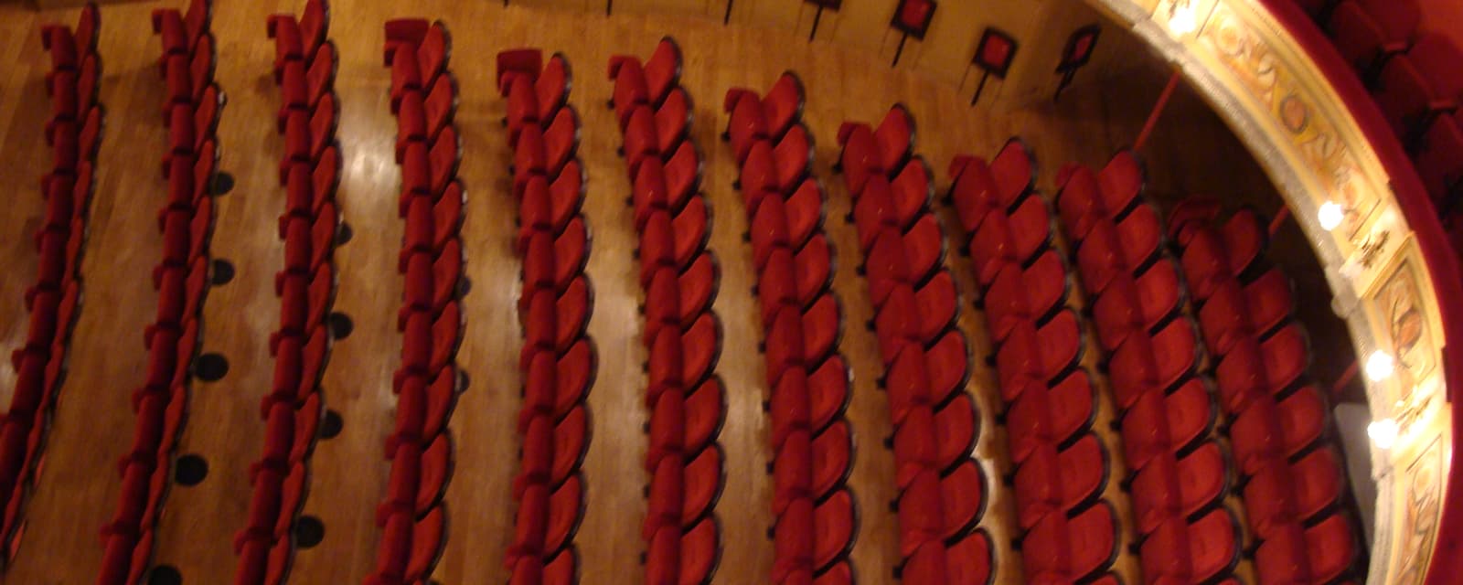 Les rangs de fauteuils rouges du parterre, vus du balcon du théâtre