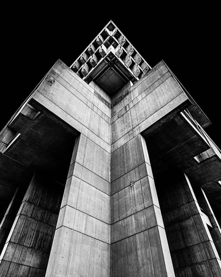 Façade de béton photographiée d'en bas en contre-plongée, noir et blanc très graphique