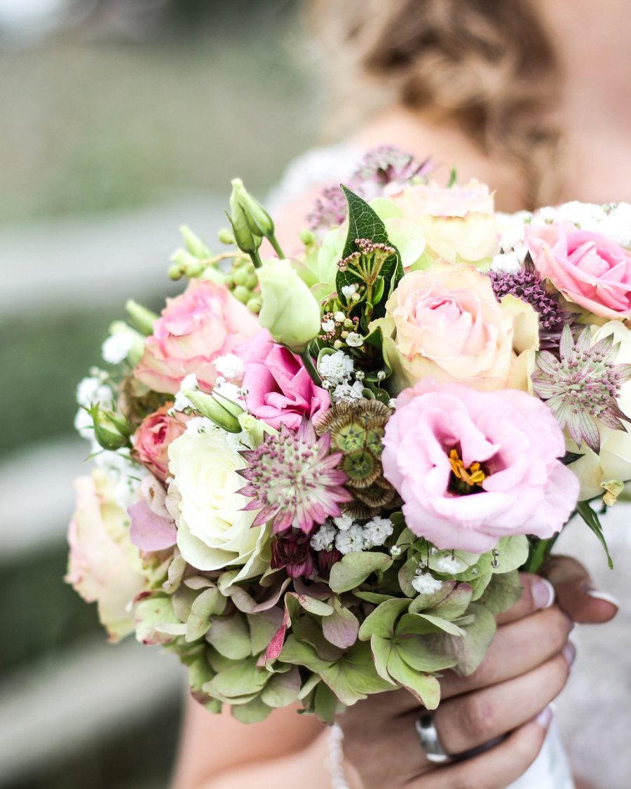 Bouquet de mariée pastel tenu à deux mains
