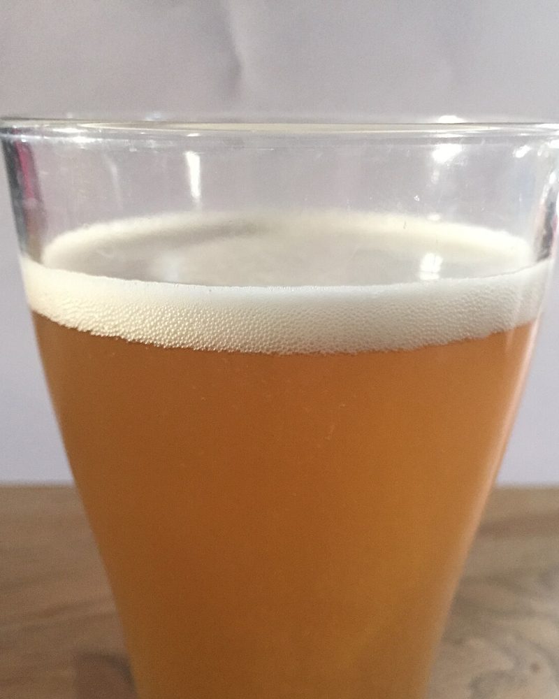 Verre de bière blanche trouble, col de mousse blanche serrée