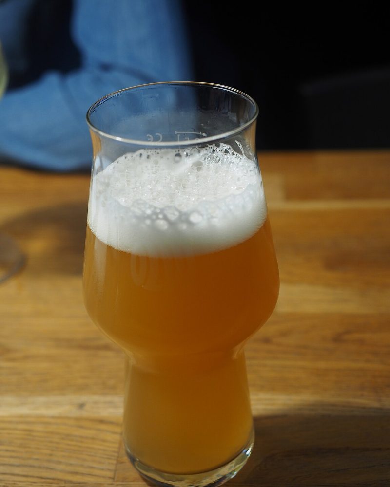 Verre de bière de blé trouble et pâle, col de mousse fine